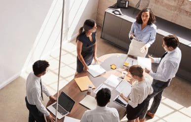 Office analysts talking about data over a table